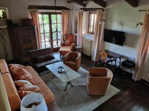uma sala de estar com um sofá, cadeiras e uma mesa em Le Querciolaie Monte Cavallo - entire house em Saturnia