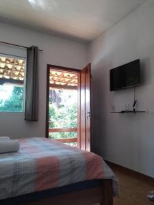 セーハ・ダ・シポーにあるEstadia cipóのベッドルーム(ベッド1台、テレビ、窓付)