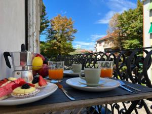 una mesa con platos de fruta y bebidas en el balcón en Ca' Yvonne alloggio a Lido di Venezia en Venice-Lido