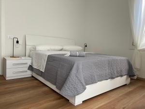 biała sypialnia z łóżkiem i stolikiem nocnym w obiekcie Ca' Yvonne alloggio a Lido di Venezia w Lido di Venezia