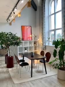 une table et des chaises dans une pièce ornée de plantes dans l'établissement Unique Central Newark Double-Height Apartment, à Newark-on-Trent