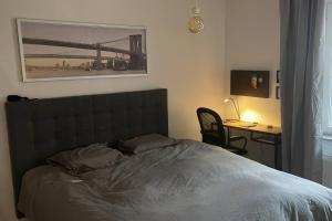 1 dormitorio con 1 cama y escritorio con ordenador en Modern & New Apartment Near CenterUniHospital With Balcony, en Uppsala
