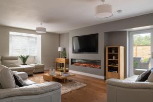 a living room with a fireplace and a tv at Arlyn, Padarn Lake Viewpoint in Snowdonia in Caernarfon