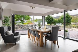 a dining room with a wooden table and chairs at Arlyn, Padarn Lake Viewpoint in Snowdonia in Caernarfon