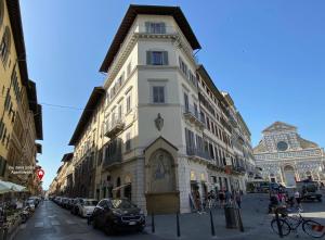 Un alto edificio bianco in una strada di città di Appartamento caratteristico Santa Maria Novella a Firenze