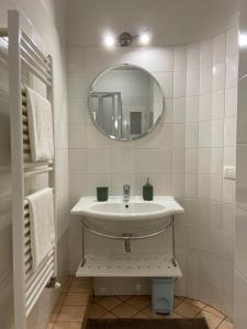 bagno bianco con lavandino e specchio di Appartamento caratteristico Santa Maria Novella a Firenze