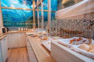 een keuken met een tafel met eten en een groot raam bij Casa da Carmen Boutique & Private Spa in Mezzolombardo