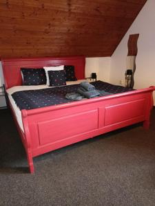 1 cama roja con marco rojo en una habitación en Rodinný penzion Barborka, en Hranice