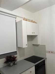 a kitchen with white cabinets and a black stove at ARTEMIS 1 Bdr Down Town Nicosia By Platform 357 in Nicosia