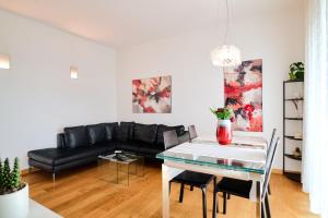 - un salon avec un canapé noir et une table dans l'établissement San Siro Design Apartment, à Milan