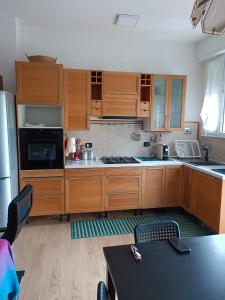 a kitchen with wooden cabinets and a stove top oven at BOLOGNA QUARTIERE SAVENA - APPARTAMENTO DI STEFANO in Bologna