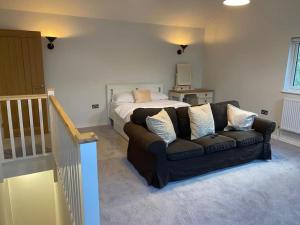 a living room with a couch and a bed at The Lodge in Royal Tunbridge Wells