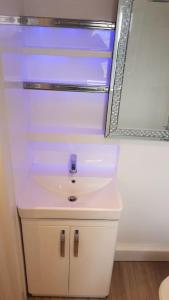 a bathroom with a white sink and a mirror at Beautiful holiday studio in the heart of Rochester in Rochester