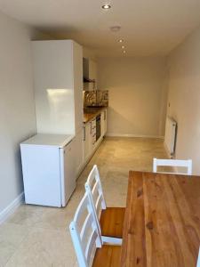 a kitchen with a table and two chairs and a refrigerator at The Lodge in Royal Tunbridge Wells
