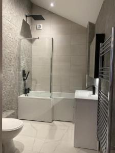y baño con ducha, aseo y lavamanos. en The Lodge en Royal Tunbridge Wells