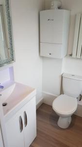 a white bathroom with a toilet and a sink at Beautiful holiday studio in the heart of Rochester in Rochester