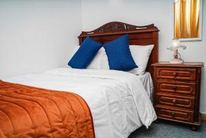 una camera da letto con un letto con cuscini blu e un comò di Residencial Airside Palace a Lisbona