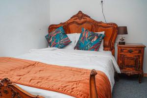 una camera da letto con letto arancione con cuscini e comodino di Residencial Airside Palace a Lisbona