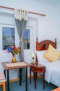 una camera da letto con un letto e un tavolo con fiori di Residencial Airside Palace a Lisbona