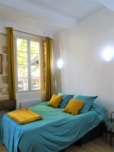 um quarto com uma cama com lençóis azuis e uma janela em BLUE FOUNTAIN Luxueux Studio Aix Centre Historique -WIFI-SMART TV- em Aix-en-Provence