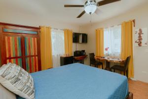 Schlafzimmer mit einem blauen Bett und einem Esstisch in der Unterkunft Oasis Diverse Adult Retreat in Quepos
