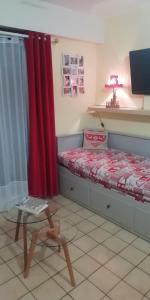 ジェラールメにあるLes Dryades L'Epicéaのベッドルーム1室(赤いカーテンとテーブル付きのベッド1台付)