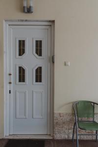 Una puerta blanca en una habitación con silla en Le Vert, en Komotiní