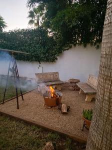 a fire pit in a backyard with a bench and a table at Eco Finca Sa Becadeta in Llucmajor