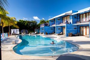 a person swimming in a pool in front of a building at True Blue Bay Resort in Saint Georgeʼs