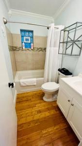 a white bathroom with a toilet and a shower at Luxury 2/2 private oasis w/Hot Tub walk to Beach in Cape Canaveral