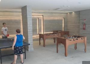 two people playing a video game in a room at Apt Salinas Premium Resort - 1007 in Salinópolis