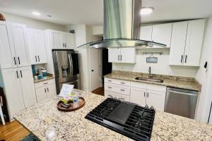 a kitchen with white cabinets and a granite counter top at Luxury 2/2 private oasis w/Hot Tub walk to Beach in Cape Canaveral
