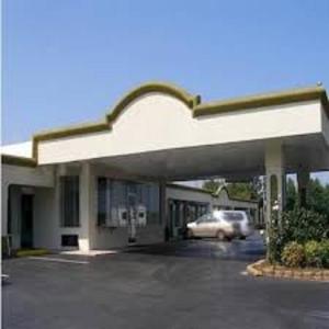 a car parked in front of a gas station at Scottish Inns - Commerce in Commerce