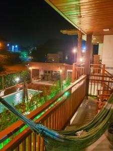 a hammock on the balcony of a resort at night at Pousada Rosa Maria in Praia do Rosa +105 photos