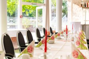 a long table with chairs and red candles on it at Hotel Bördehof, direkt an der A2 & A14, Restaurant, Tagung, individuell in Barleben