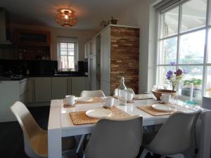 een witte tafel in een keuken met stoelen en een tafel bij Comfortabel en gezellig vakantiehuis bij het strand in Wemeldinge