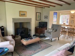 a living room with a couch and a fireplace at Pretty Yorkshire Stone Cottage Harome in Harome