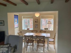 a dining room with a table and chairs at Pretty Yorkshire Stone Cottage Harome in Harome