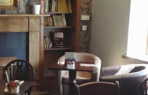 a living room with a table and a chair at Laird And Dog Inn in Lasswade