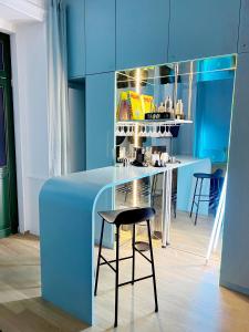 una cocina azul con taburete y barra en Sissi West, en Viena