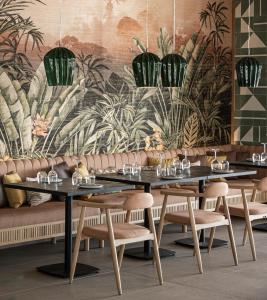 un comedor con 2 mesas y sillas y un mural en Eden Roc Resort - All Inclusive en Kallithea Rhodes