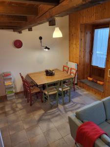 a dining room with a table and chairs and a couch at Mansarda Abetone in Abetone