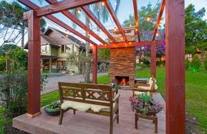 a patio with two benches and a fireplace at Hotel Canto Verde in Gramado