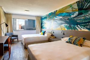a hotel room with two beds and a mural on the wall at Palladium Business Hotel in Montevideo