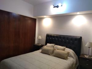 a bedroom with a large bed with a black headboard at Paraíso Costero San Bernardo in San Bernardo