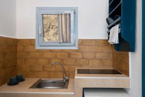 cocina con fregadero y ventana en TA PLAGIA accommodation en Anafi