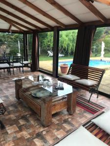 un patio con mesa, bancos y piscina en HOTEL BOUTIQUE CASA BLANCA, en Chillán