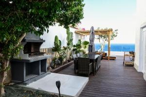 a wooden deck with a table and an umbrella at DELFIN Luxury Villa Water Front Jacuzzi in Águilas