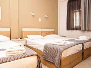 a room with three beds with towels on them at Afrodite Beach in Nei Poroi