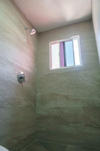a bathroom with a shower with a window at Access Blue Cristal in Monterrey